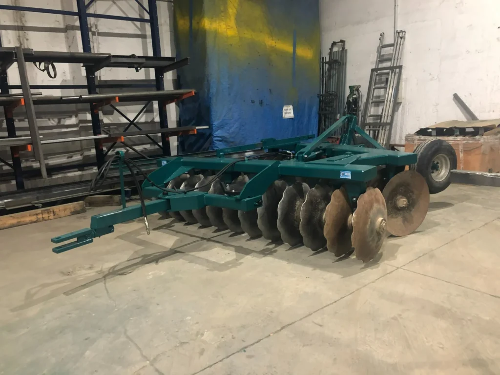Vista en perspectiva del arado completo con discos y enganche delantero, ubicado en el interior de nuestro taller.
