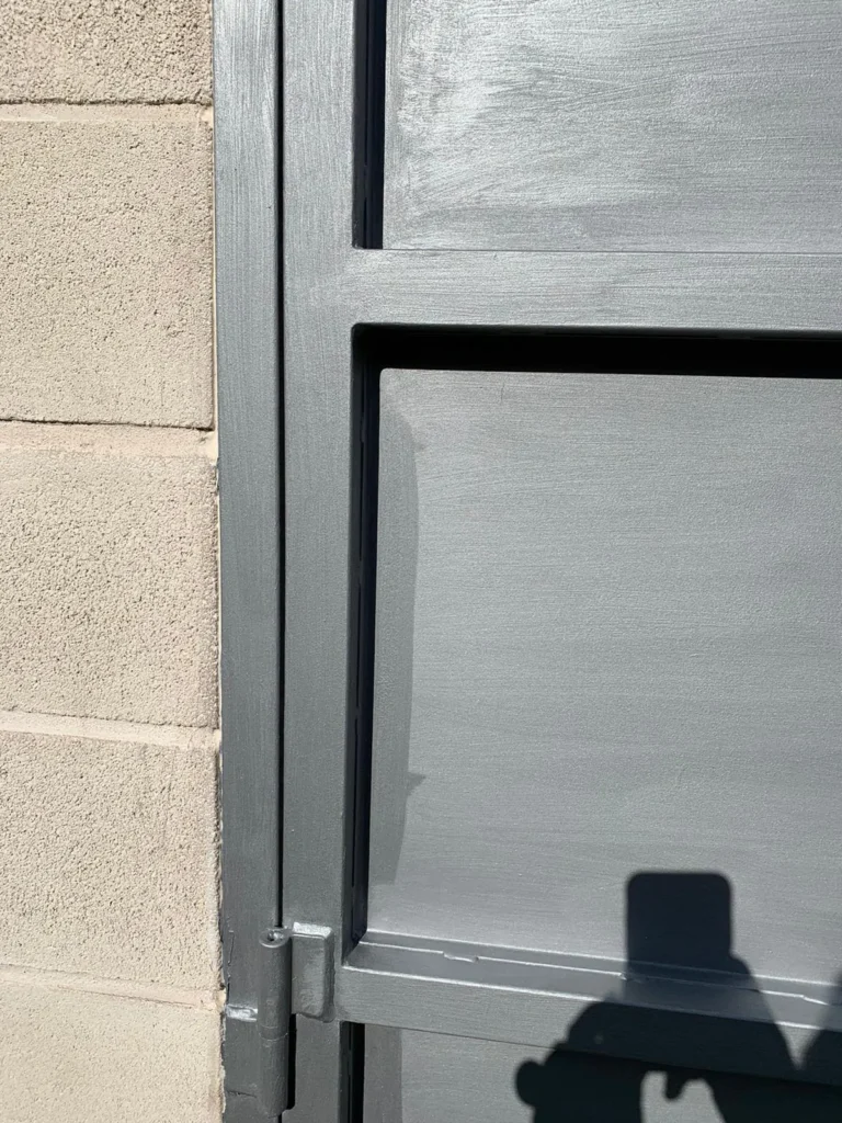Vista en primer plano del marco y bisagra de una puerta gris metálica