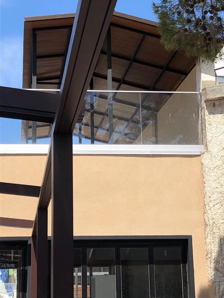 Detalle de cubierta superior con barandilla de cristal y estructura metálica