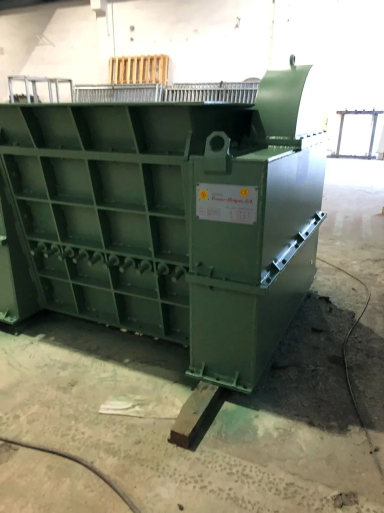 Vista lateral de una máquina industrial verde de grandes dimensiones, ubicado en el interior de nuestro taller.