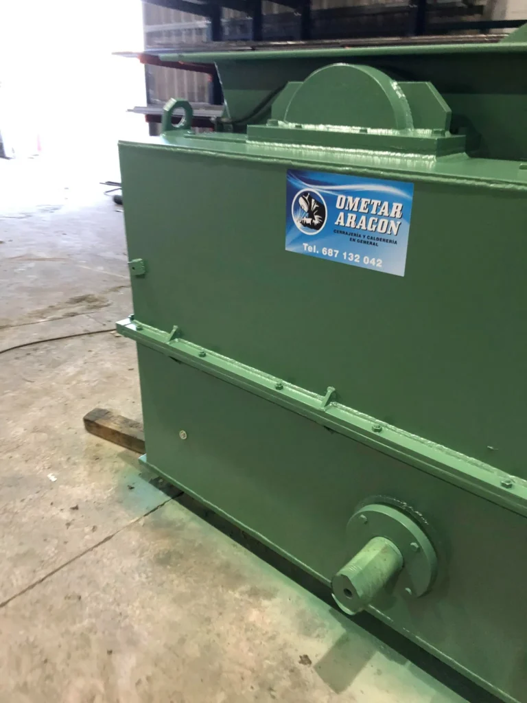 Parte trasera de un equipo industrial con eje metálico y logotipo de 'OMETAR ARAGÓN', en el interior de nuestro taller.